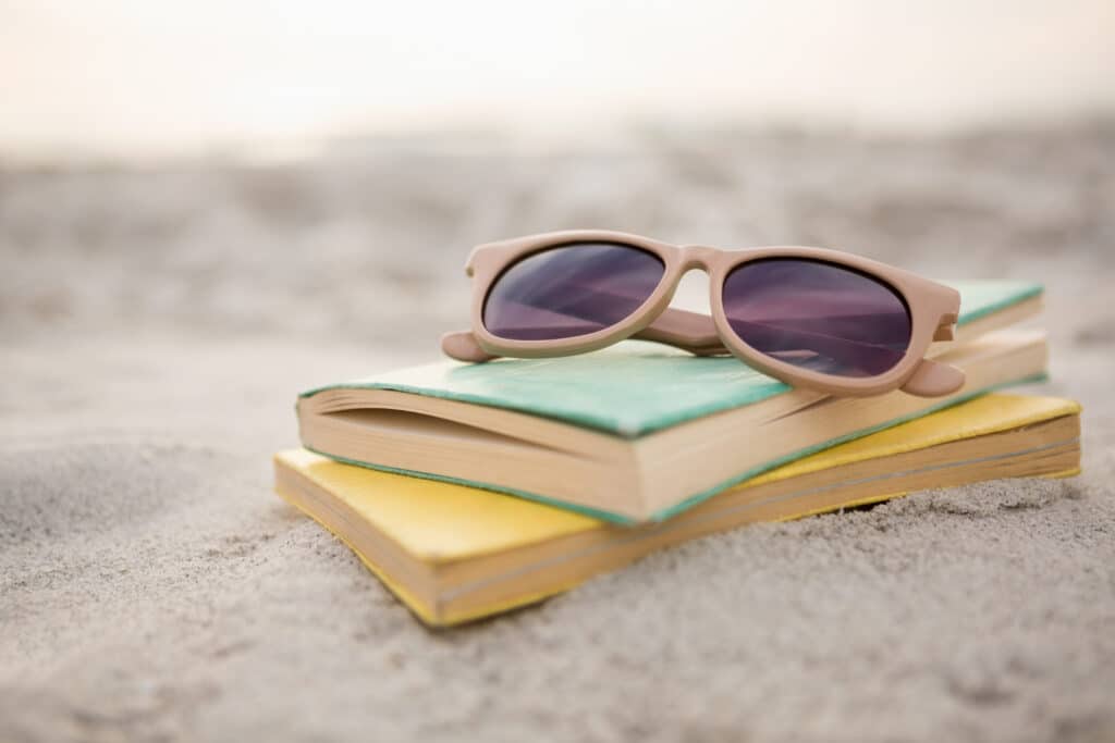 Sunglasses and books on sand